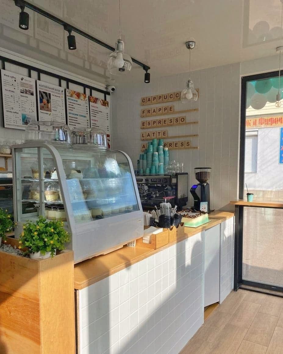Inside a Crema Caffe coffee shop, with the counter and espresso machine