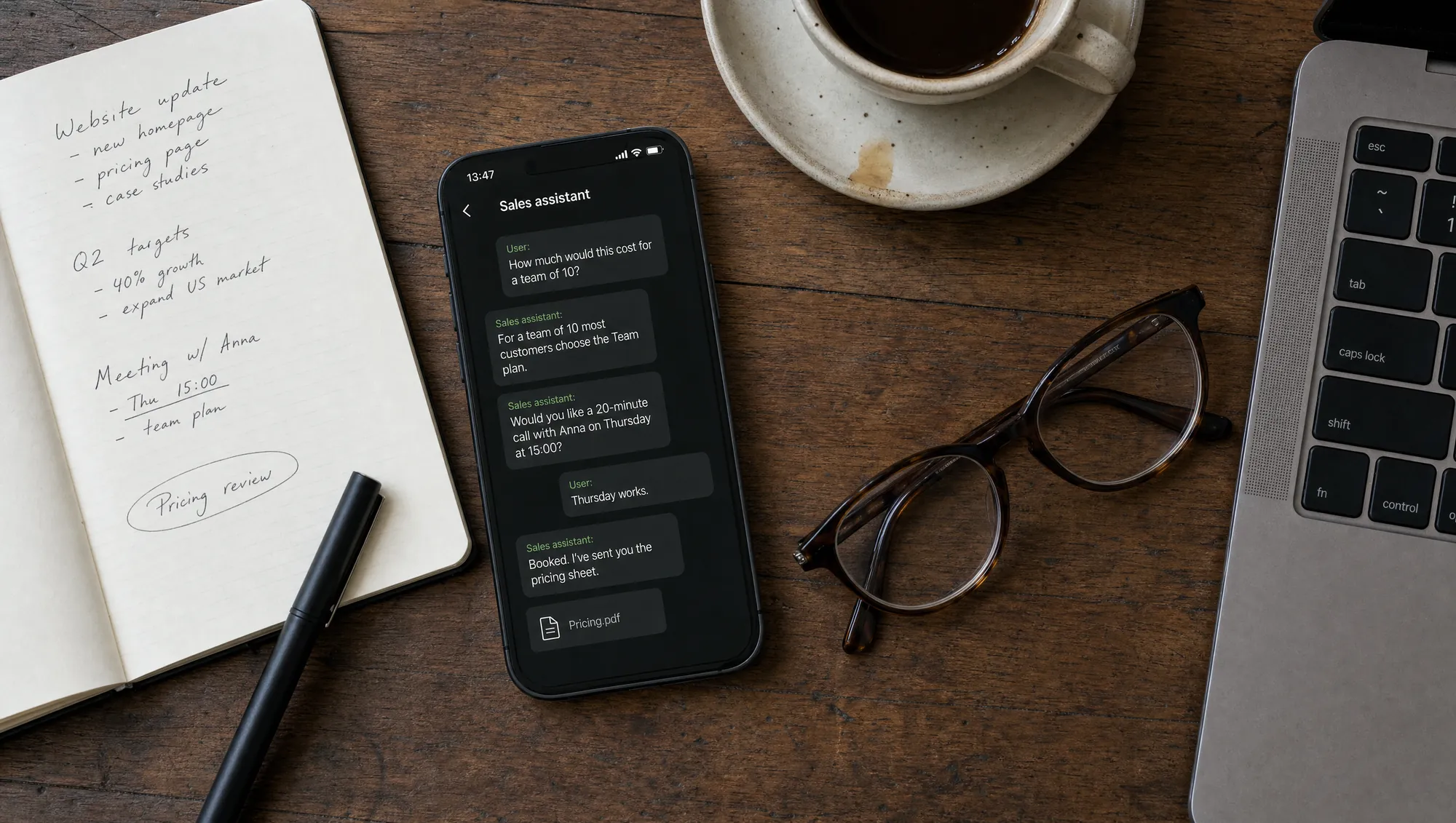 Smartphone on a wooden desk showing a sales assistant chat: a pricing question for a team of 10, a call with Anna on Thursday at 15:00 and a Pricing.pdf attachment