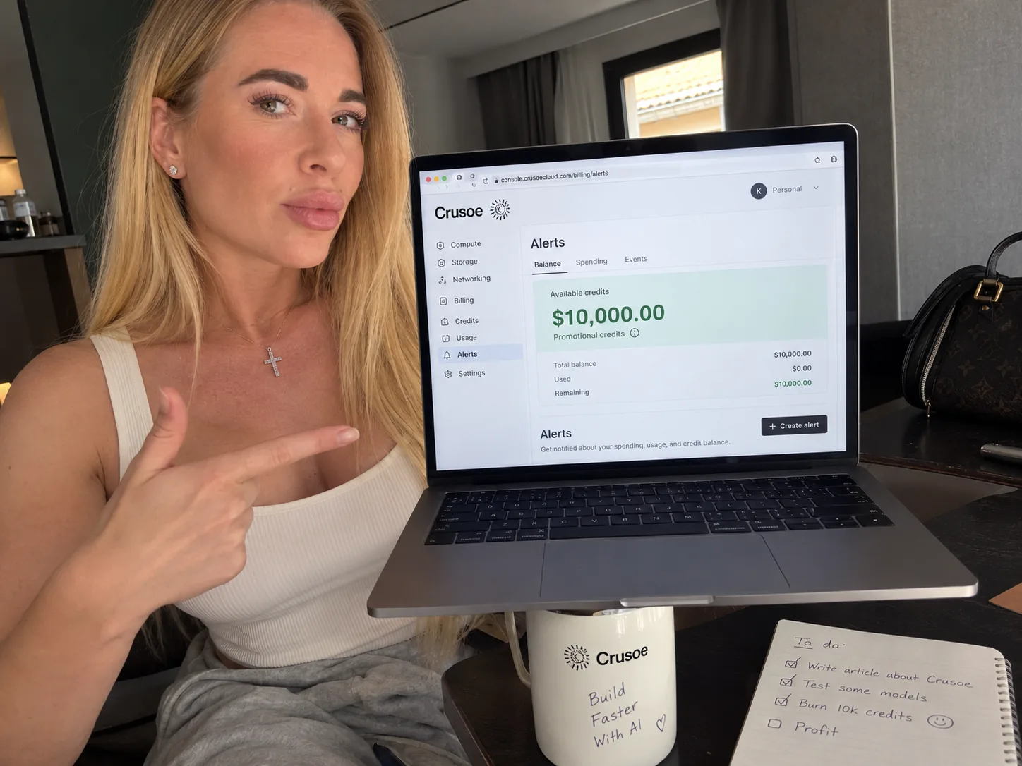 Tetiana Stepanets pointing at the Crusoe Cloud console, which shows $10,000.00 in available promotional credits
